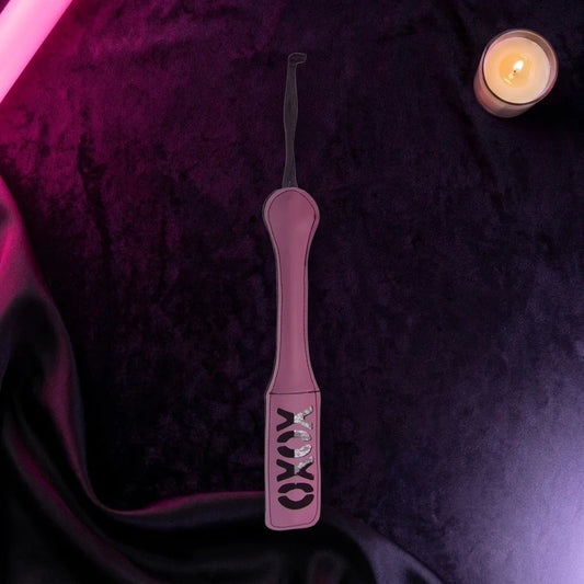 Pink XOXO cut-out paddle on dark velvet