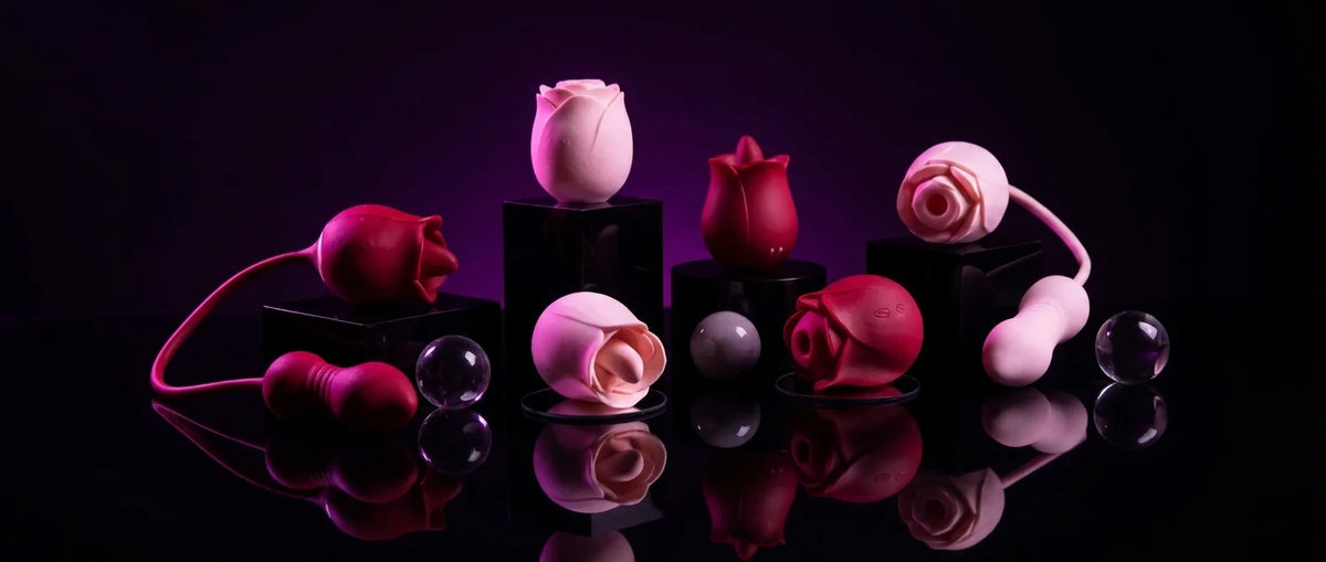A set of intimate rose toy sex toys styled like flowers and shaped like berries, displayed on black pedestals against a dark purple and black background with reflective surfaces.